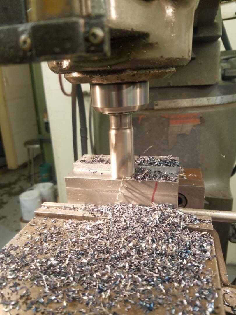 A milling machine cutting metal and producing shavings.