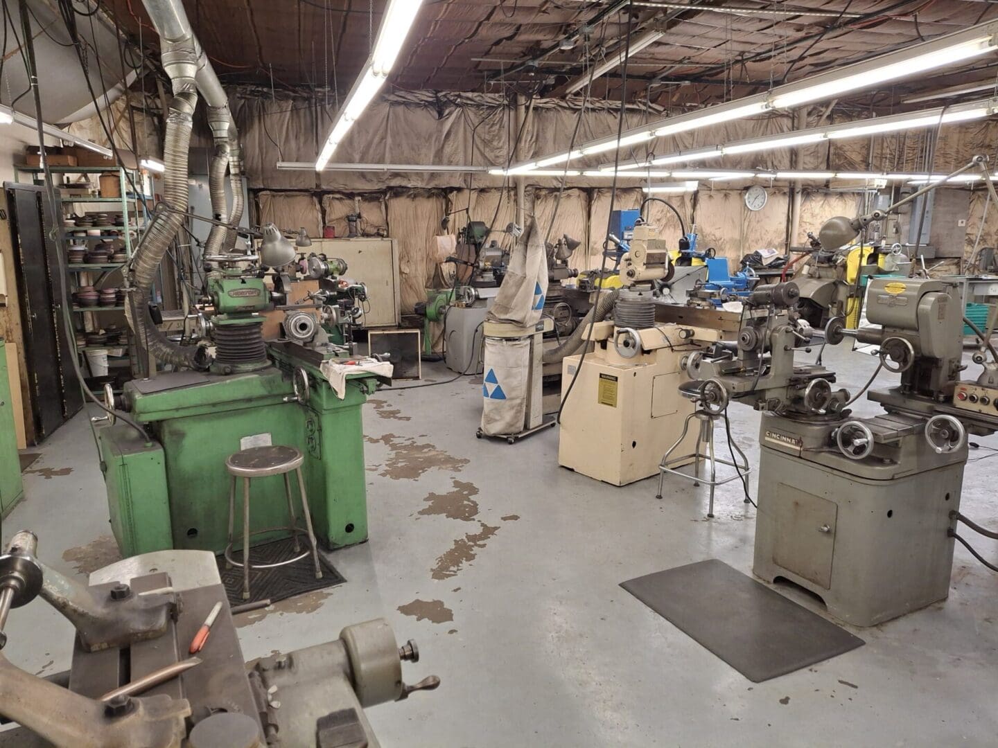 A cluttered workshop with various machines and tools scattered around.