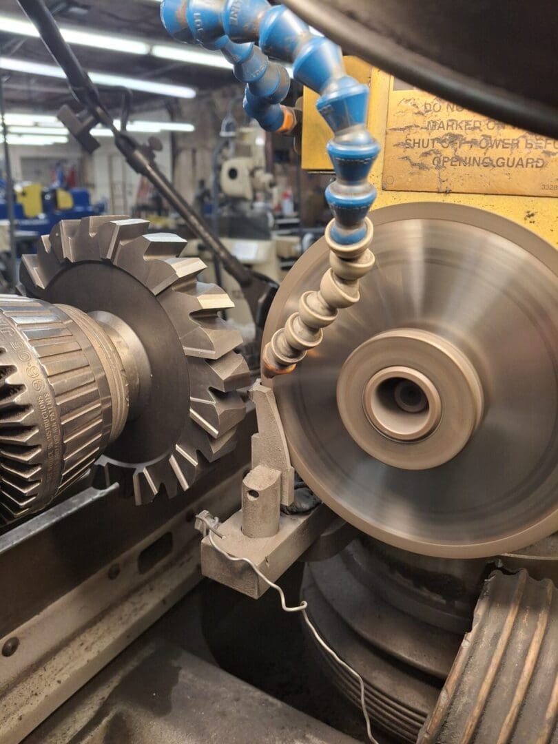 A metal lathe machine shaping a cylindrical workpiece in a workshop.